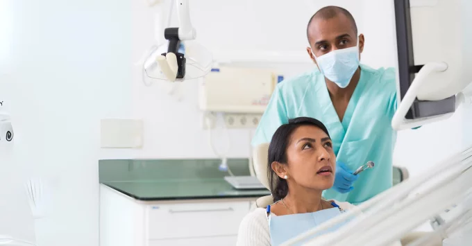 Hygienist reviewing images on screen with patient