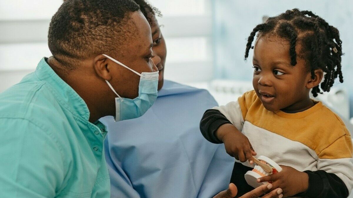 Clinician treating child in mother's lap